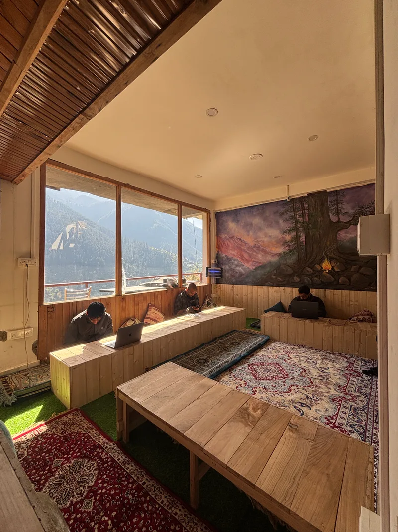 Inside the Emberwood café — wooden floors, Persian rugs and tall mountain-view windows